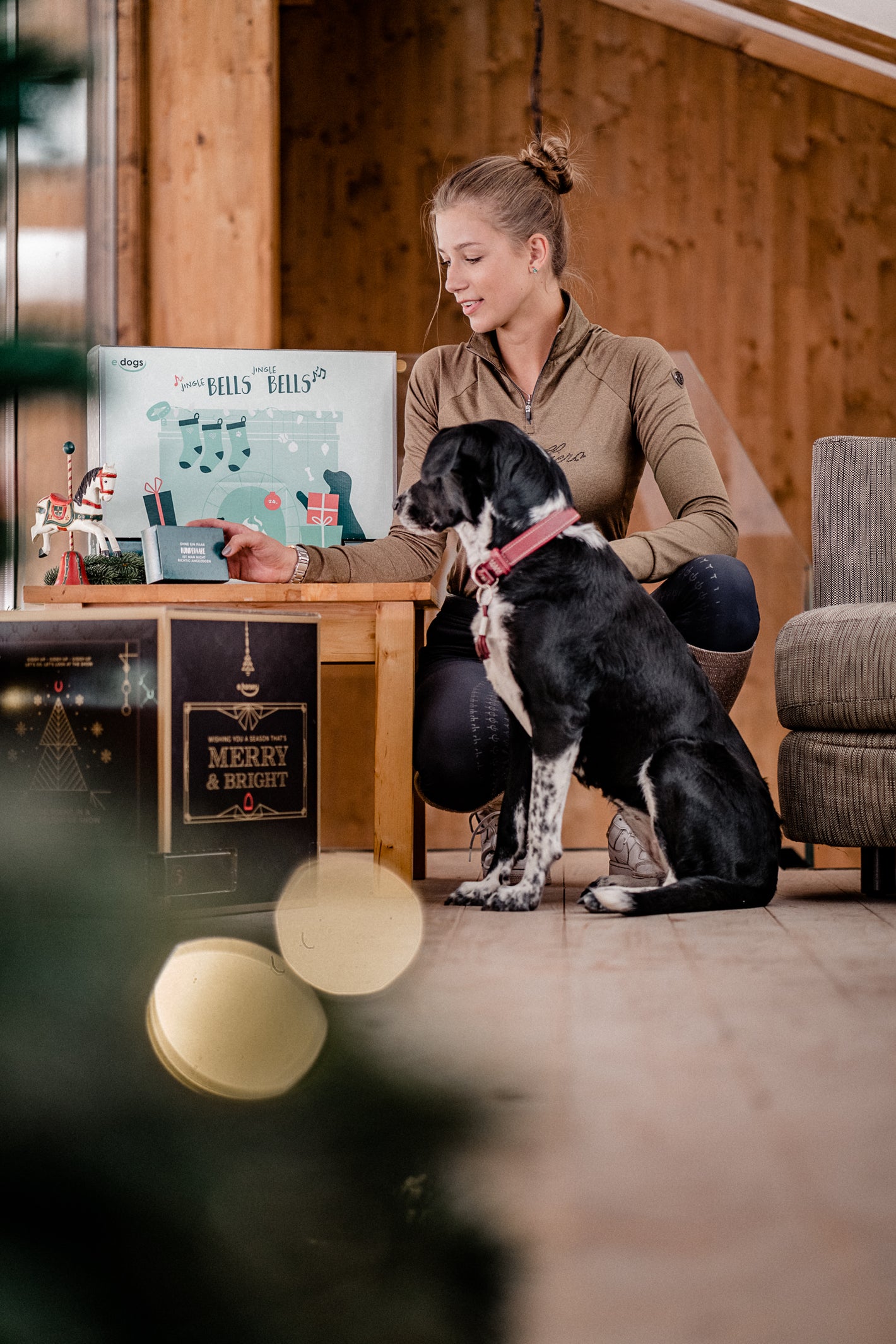 Junge Frau betrachtet mit ihrem Hund die Inhalte vom Hunde Adventskalender